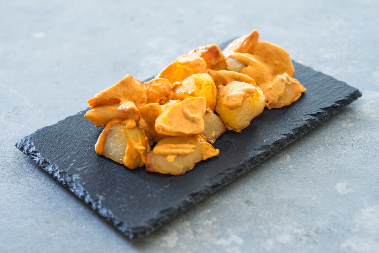 Patatas Bravas on a Black Wooden Board